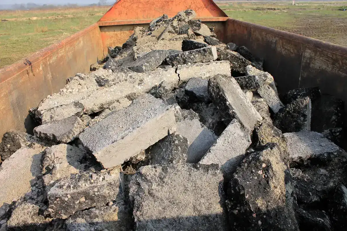 Blocs de béton et d'enrobé concassés remplissant une benne de chantier