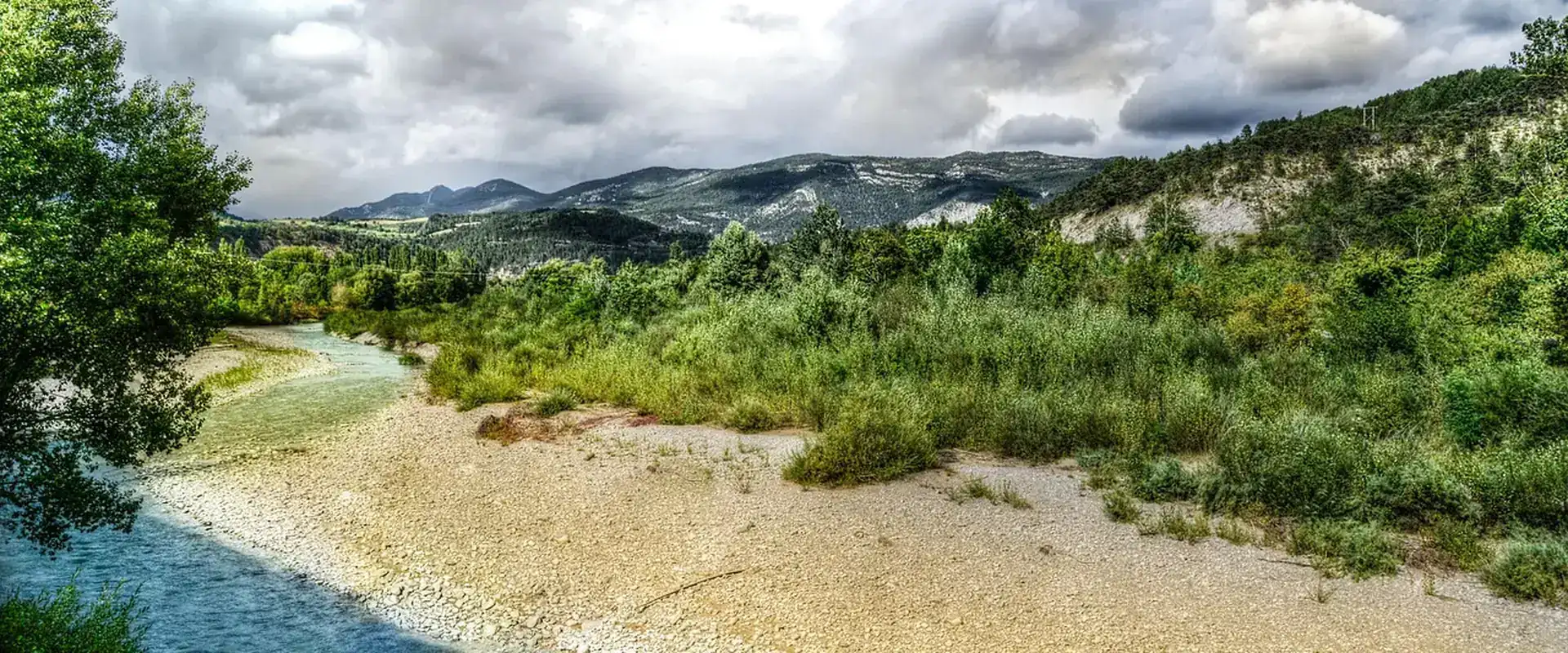 Vallée bordée de collines boisées traversée par une rivière, paysage du sud-est de la France
